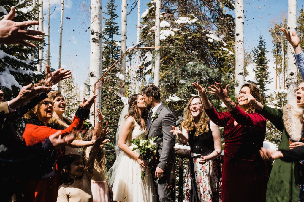 Couple kisses for an outdoor petal toss.