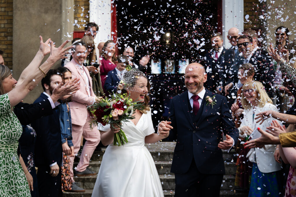 Couple walks down steps during a flower petal toss.