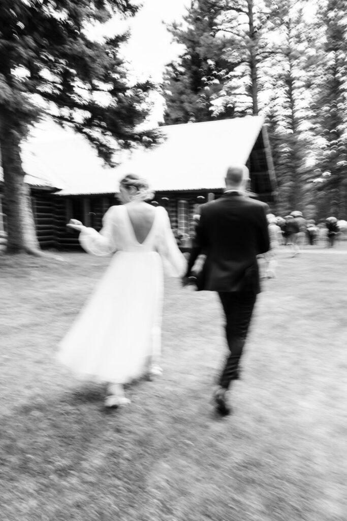 Bride and groom walking during recessional with intentional motion blur capturing the energy and pace of the moment