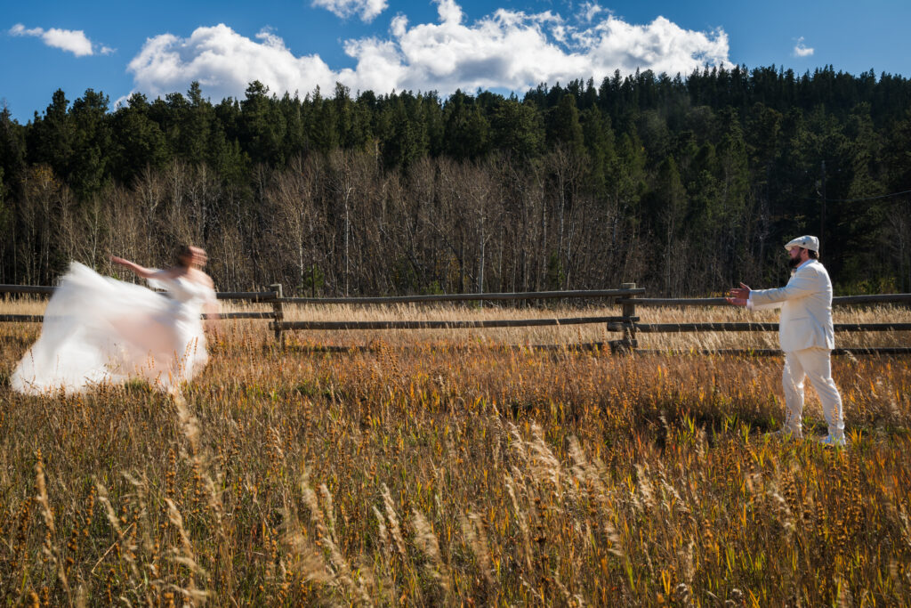 Bride standing still with sharp focus while blurred motion of surrounding guests creates visual contrast