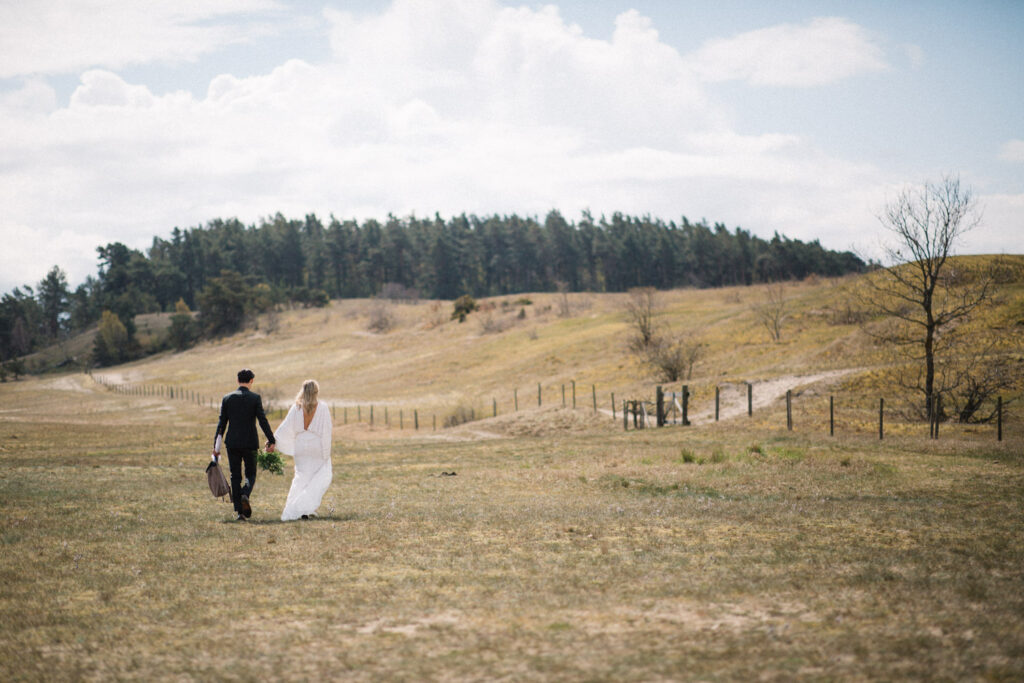 Couple walking away across open grassland under a big sky